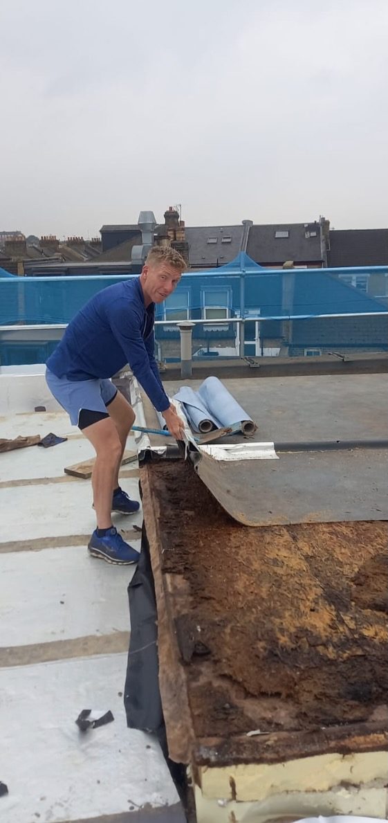 Adam Street on the Hafer Road roof, personally stripping the old waterproofing membrane.